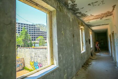 KUPARI, CROATIA - JULY 19, 2017 : A woman standing in the hall of an old ruined hotel Grand in abandoned Yugoslavian military resort in Kupari, Croatia.のeditorial素材