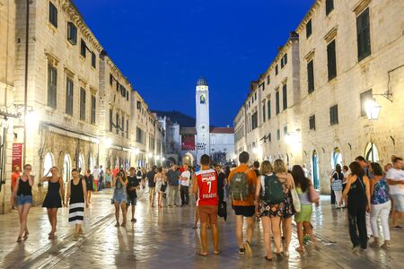 DUBROVNIK, CROATIA - JULY 22, 2017 : People walking in the main city street Stradun at sunset with the city belfry in the background in Dubrovnik, Croatia.のeditorial素材