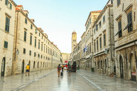 DUBROVNIK, CROATIA - JULY 22, 2017 : Tourists walking in the main city street Stradun with the bell tower of the Franciscan church in the background  in Dubrovnik, Croatia.のeditorial素材