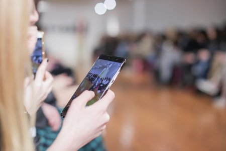 ZAGREB, CROATIA- MARCH 15, 2018: Audience filming with smartphone video of fashion model wearing clothes for spring-summer, designed by I-GLE on the Bipa Fashion.hr fashion show in Zagreb, Croatia.のeditorial素材
