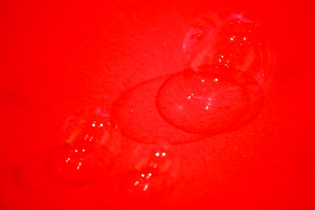Abstract image of soap bubbles from the bubble blower on the red floor.の写真素材