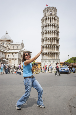 PISA, ITALY - 21 JUNE, 2006 : The woman imitates the posture of the Tower of Pisa in Pisa, Italy.のeditorial素材