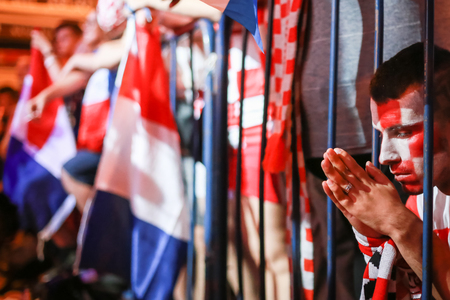 ZAGREB, CROATIA - JULY 7TH, 2018 : Croatian football fan praying for win of Croatia of quarterfinal game Croatia vs Russia on Fifa World cup 2018 on Ban Jelacic Square in Zagreb, Croatia.のeditorial素材