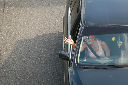 ZAGREB, CROATIA - August 11th, 2018 : Happy woman waving to the camera during traffic jam due to the large number of tourists going to the sea coast of Croatia in the Lucko highway toll in Zagreb.のeditorial素材