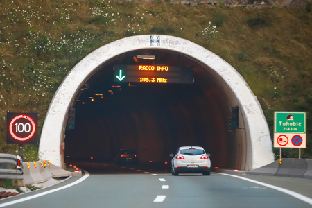 Tuhobic, Croatia - August 1th, 2018 : White car driving in to the tunnel Tuhobic with speed limit sign of 100 km/h in Tuhobic, Croatia.のeditorial素材