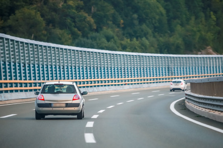 Rear view of car driving on the highway with noise barrier.の写真素材