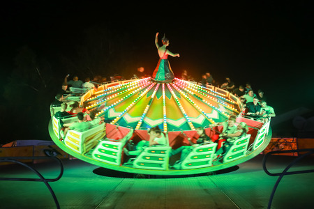 Vukovina, Croatia - August 15, 2018 : People riding on a modern carousel in an amusement park on a fair in Vukovina, Croatia.のeditorial素材