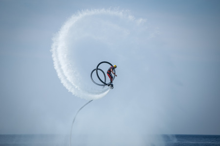 Dugi Rat, Croatia - October 20, 2018: A man is doing acrobatics with flyboard attached to jet ski close to the shore in Dugi Rat, Croatia.のeditorial素材