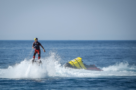 Dugi Rat, Croatia - October 20, 2018: A man is doing acrobatics with flyboard attached to jet ski close to the shore in Dugi Rat, Croatia.のeditorial素材