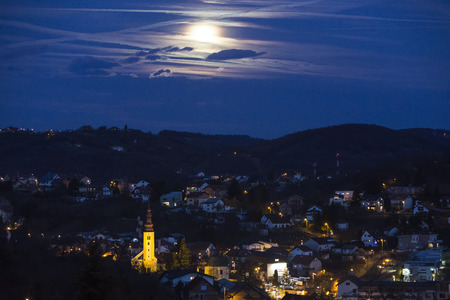 Church in the village with full moon at nightの写真素材