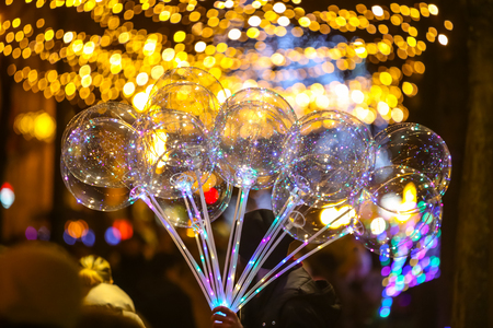 Zagreb, Croatia - December 29, 2018 : A man selling illuminating balloons with led diodes in the street during the night.のeditorial素材