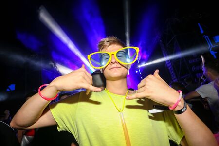 Brezje, Croatia - 20th July, 2019 : Man posing with big yellow sunglasses on the Forestland, ultimate forest electronic music festival located in Brezje, Croatia.のeditorial素材
