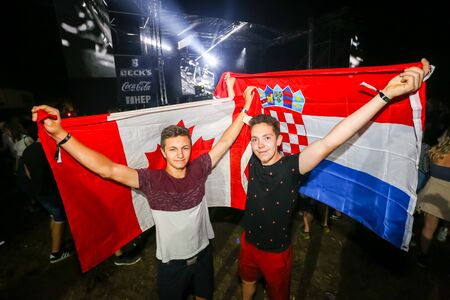 Brezje, Croatia - 20th July, 2019 : Two guys with a Canadian and Croatian flag posing on the Forestland, ultimate forest electronic music festival located in Brezje, Croatia.のeditorial素材