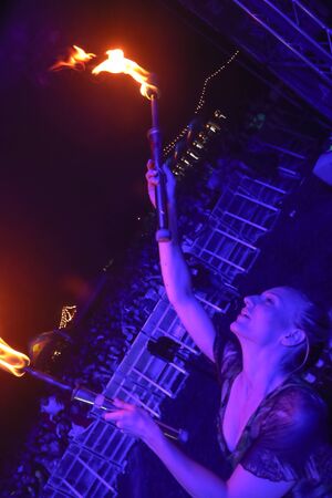 Brezje, Croatia - 20th July, 2019 : A woman juggling with a fire on the stage on the Forestland, ultimate forest electronic music festival located in Brezje, Croatia.のeditorial素材