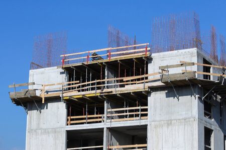The construction work on a building on a sunny day with clear blue sky.