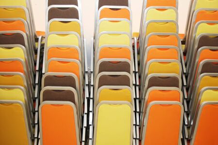 An abstract background of stacked colorful chairs.