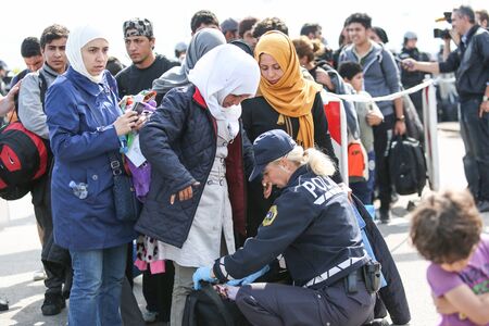 Bregana, Slovenia - September 20, 2015 : The police checking syrian refugees at the slovenian border with Croatia. The migrants are waiting for the authorities to open the border crossing, so they can continue to the northern european countries.のeditorial素材