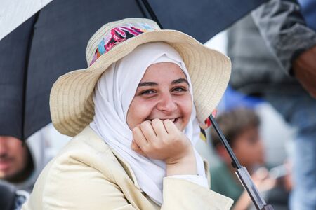Bregana, Slovenia - September 20, 2015 : A front view of a Syrian woman with scarf smiling at the camera on the slovenian border with Croatia. The migrants are waiting for the authorities to open the border crossing, so they can continue to the northern eのeditorial素材