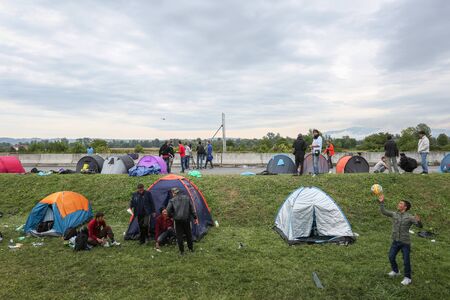 Bregana, Slovenia - September 20, 2015 : The syrian refugees in tents on the slovenian border with Croatia. The migrants are waiting for the authorities to open the border crossing, so they can continue to the northern european countries.のeditorial素材