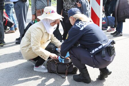 Bregana, Slovenia - September 20, 2015 : The police checking syrian refugees at the slovenian border with Croatia. The migrants are waiting for the authorities to open the border crossing, so they can continue to the northern european countries.のeditorial素材
