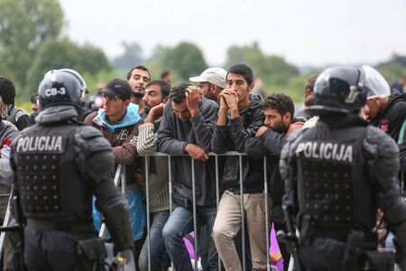 Bregana, Slovenia - September 20, 2015 : A large group of male syrian refugees at the slovenian border with Croatia. The migrants are waiting for the authorities to open the border crossing, so they can continue to the northern european countries.のeditorial素材