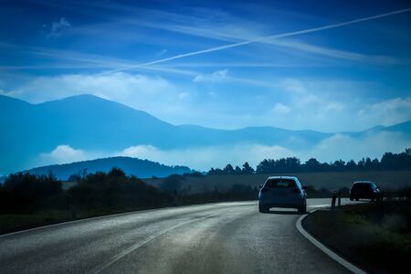 Rear view of two cars driving on the two way road with landscape of Gorski Kotar in Croatia.