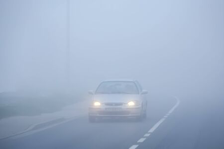 Zagreb, Croatia - 27th October, 2019 : Traffic on the two way road during thick morning fog.のeditorial素材