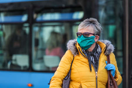 Zagreb, Croatia - March 19, 2020 : People on the street of Zagreb wear protective masks because of...