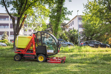 Zagreb, Croatia - April 22, 2020 : Utility workers mow the city park with trimmers and lawn mowers...