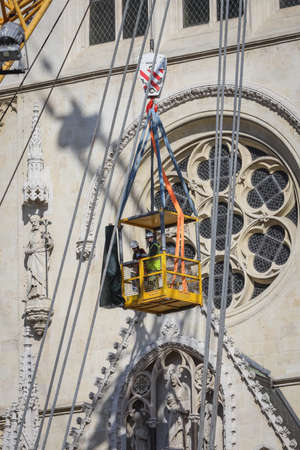 Zagreb, Croatia - April 15, 2020 : Workers with tall cranes are preparing to separate top of the Zagreb Cathedral tower that was damaged by the earthquake of 5.5 on the Richter scale one month ago.のeditorial素材