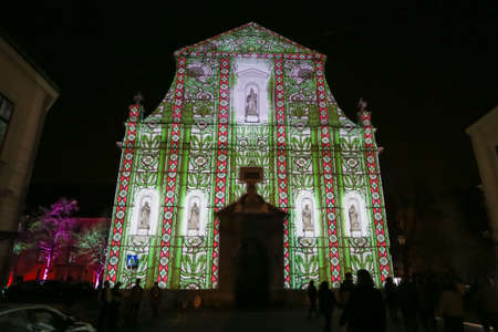 Zagreb, Croatia - 24 March, 2019 : Festival of lights in Zagreb, Croatia. People walking next to illuminated with a drawing church of St. Catherine in the upper town.のeditorial素材