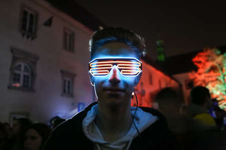 Zagreb, Croatia - 24 March, 2019 : A man with lighted glasses during Festival of lights in upper town in Zagreb, Croatia.のeditorial素材