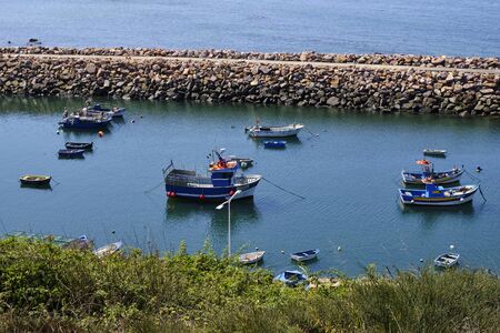 Boats in a natural harbor in the cliff. Solo Backpacker Trekking on the Rota Vicentina and Fishermen's Trail in Alentejo, Portugal. Walking between cliff, ocean, nature and beach.の写真素材