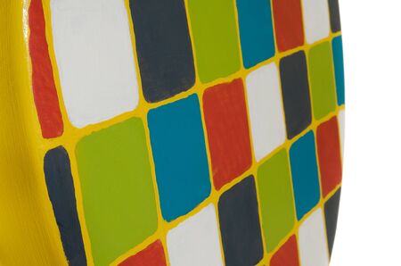 Handmade stool. Hand painted wooden yellow. Round seat wooden, painted in multicolored squares. Object isolated on a white background.の写真素材