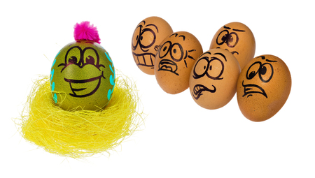 Easter eggs, hand-made painted in various patterns and colors with cartoon faces. Eggs in natural colors look with horror, astonishment and fear at colored smiling face of Easter eggs in a bird's nest.の写真素材
