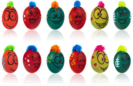 Easter eggs, hand-painted with smiling and terrified cartoon faces. Decorated eggs with funny colorful hairstyles put in a cardboard box, container for eggs. Figures on a white backgroundの写真素材