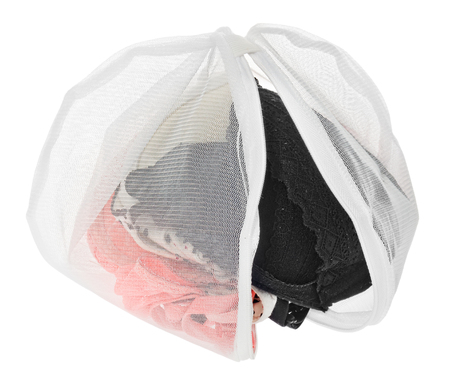 Wash bag for delicate clothes, shoes, underwear, bra. A laundry bag made of white mesh filled bras, isolated on a white background.の写真素材