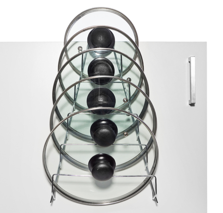 A hanger with glass lids for cooking pots hung on the door of a kitchen cupboard. Hanger adapted for hanging on kitchen railings. Made of aluminum, silver wire, isolated on a white background.の写真素材