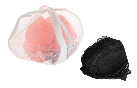Wash bag for delicate clothes, shoes, underwear, bra. A laundry bag made of white mesh filled bras, isolated on a white background.の写真素材