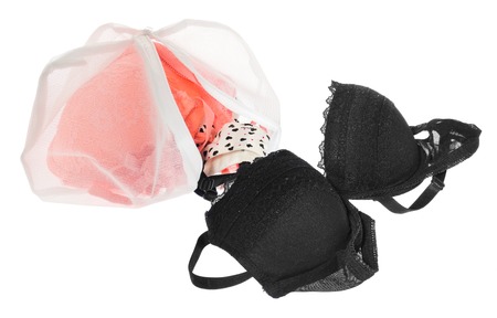 Wash bag for delicate clothes, shoes, underwear, bra. A laundry bag made of white mesh filled bras, isolated on a white background.の写真素材