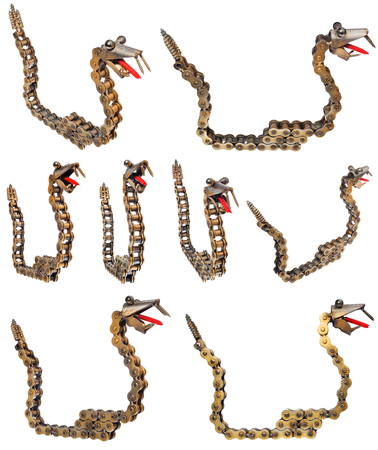 Handmade metal decorative snake. Reptile made of motorcycle parts chain, bearings, screws. Artistic object painted on gold, isolated on a white background.の写真素材