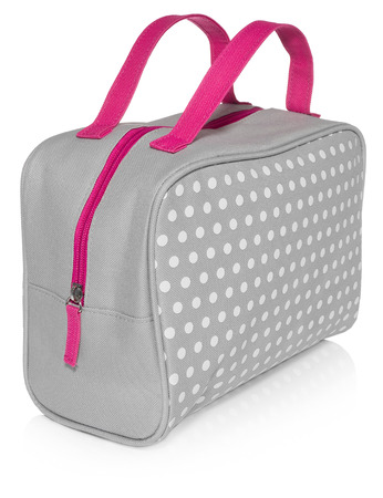 Women's beautician to store cosmetics. Purse for women made of gray material with white dots with a pink handle, space for a logo. Fashionable object isolated on a white background.の写真素材