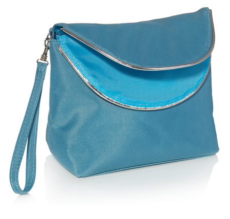 Women's beautician to store cosmetics. Purse for women made of turquoise material with silver borders, space for a logo. Fashionable object isolated on a white background with a slight reflection.の写真素材