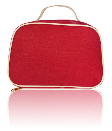 Women's beautician to store cosmetics. Purse for women made of red material, space for a logo. Fashionable object isolated on a white background with a slight reflection.の写真素材