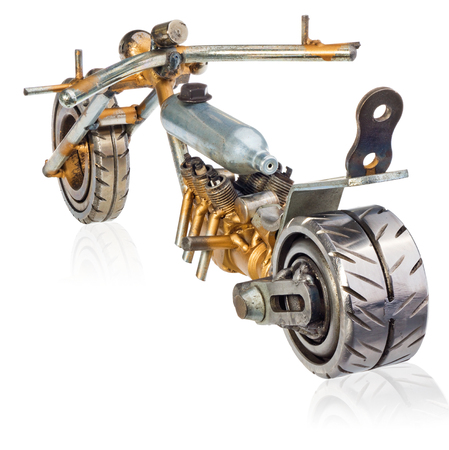 Handmade miniature of a chopper motorcycle. Decorative vehicle made of mechanical parts, bearings, wires, car candles, screws, plates. Toy in silver-gold colors, isolated on a white background.の写真素材