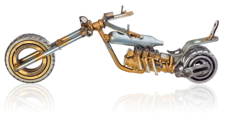 Handmade miniature of a chopper motorcycle. Decorative vehicle made of mechanical parts, bearings, wires, car candles, screws, plates. Toy in silver-gold colors, isolated on a white background.の写真素材