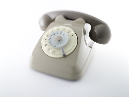 old rotating dial telephon over a white backgroundの写真素材