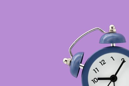 Classic alarm clock isolated on purple background.の写真素材