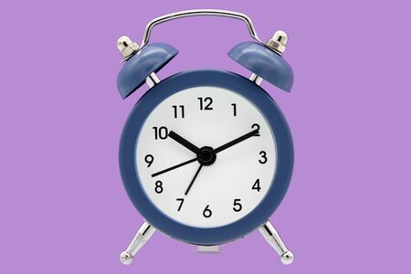 Classic alarm clock isolated on purple background.の写真素材