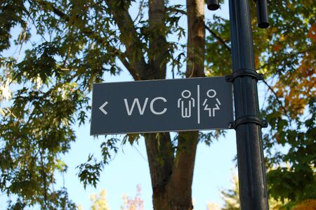 Sign of public toilets WC. toilet sign and arrow. Sign pointing towards the WC. City Park